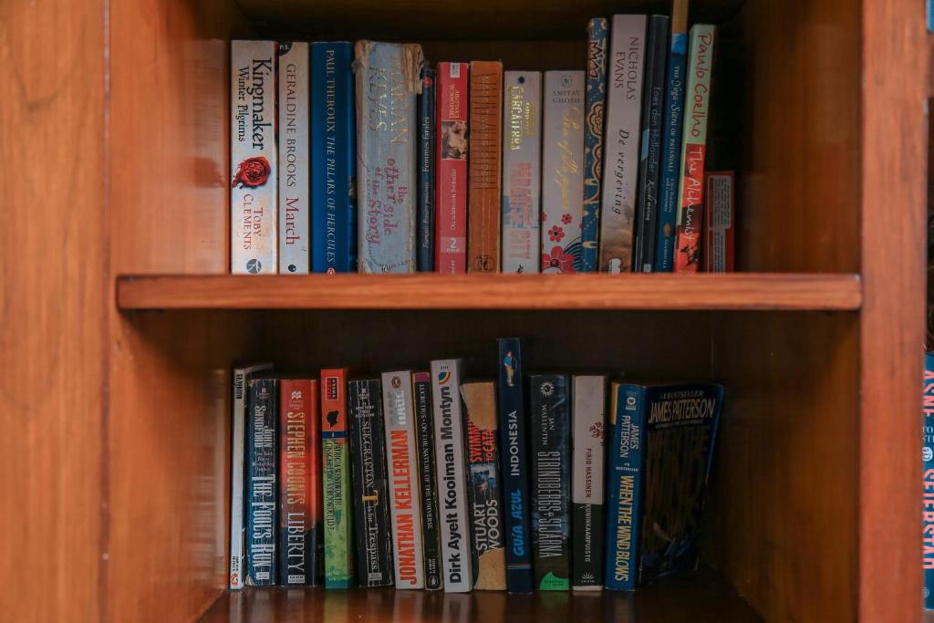 a book shelf filled with lots of books at Alia Home in Sanur