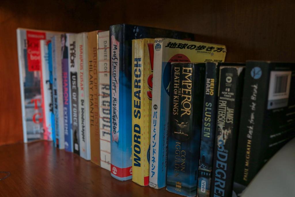 a row of books sitting on a book shelf at Alia Home in Sanur