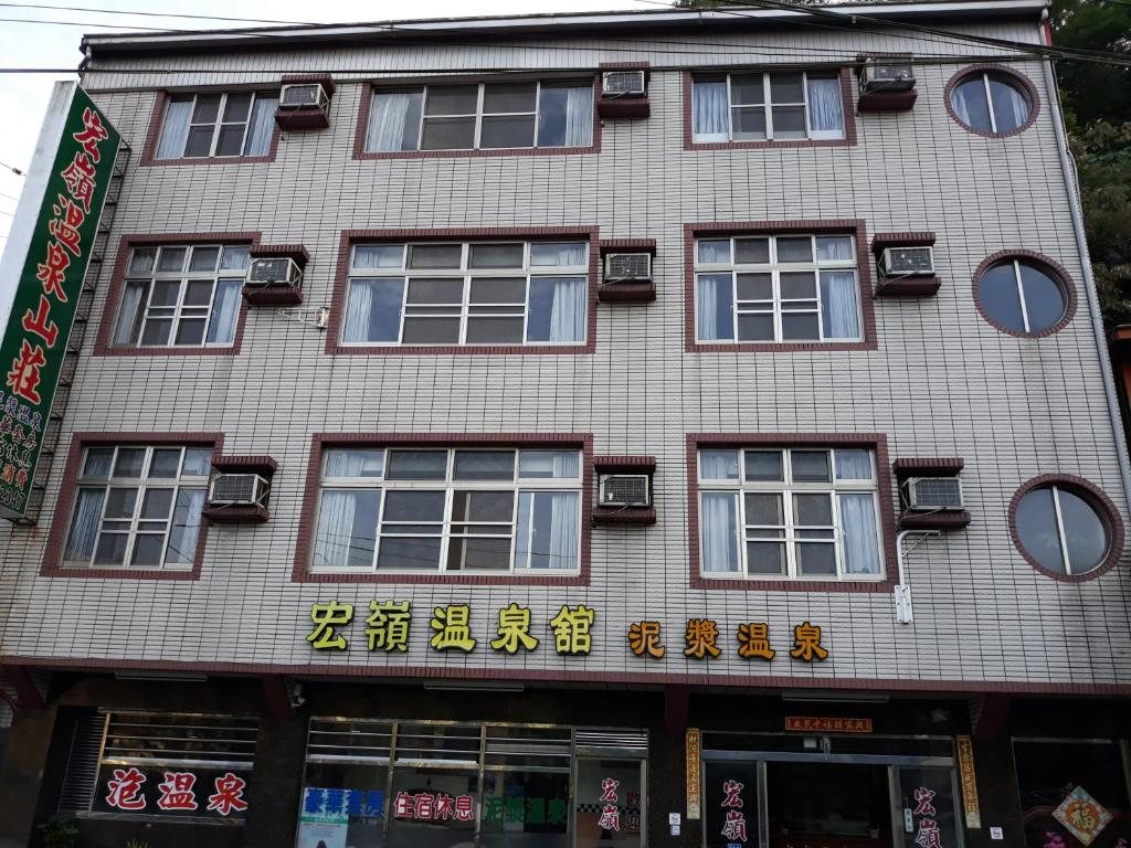 um edifício com escrita chinesa ao lado em 宏嶺溫泉山莊 em Baihe