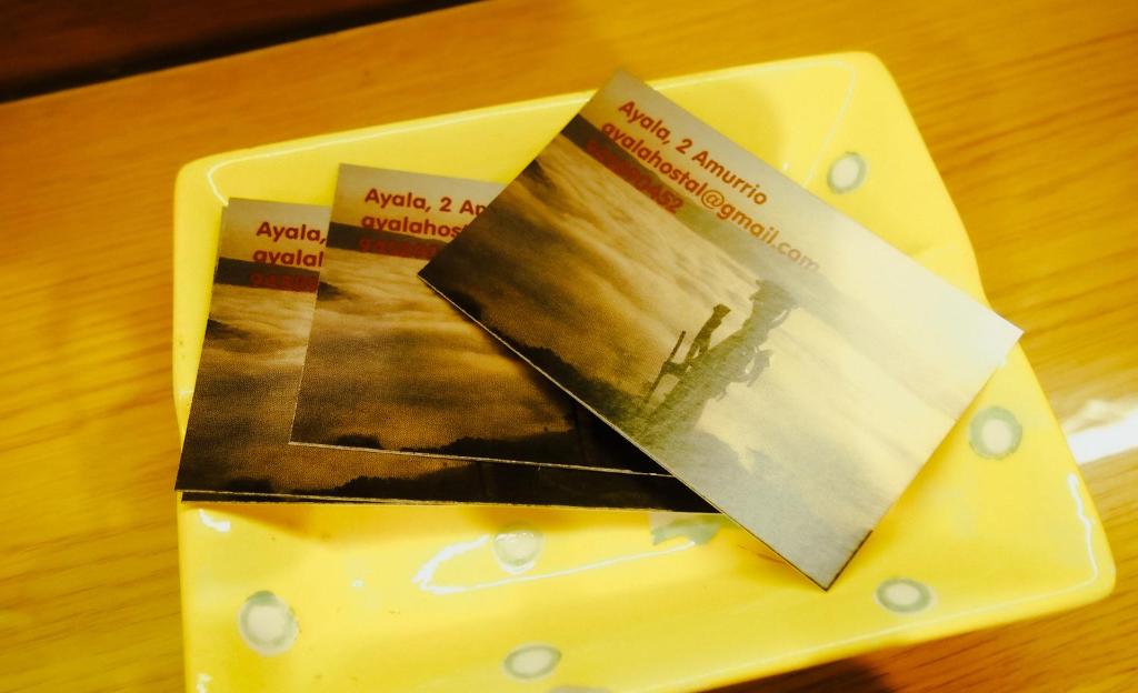dos libros sentados en un plato amarillo en una mesa en Pensión Ayala, en Amurrio
