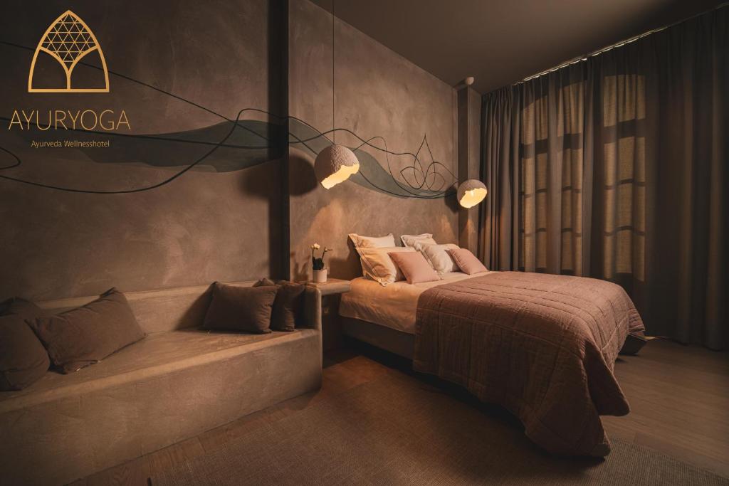 een slaapkamer met een bed en een bank erin bij Ayuryoga Wellnesshotel in Petegem