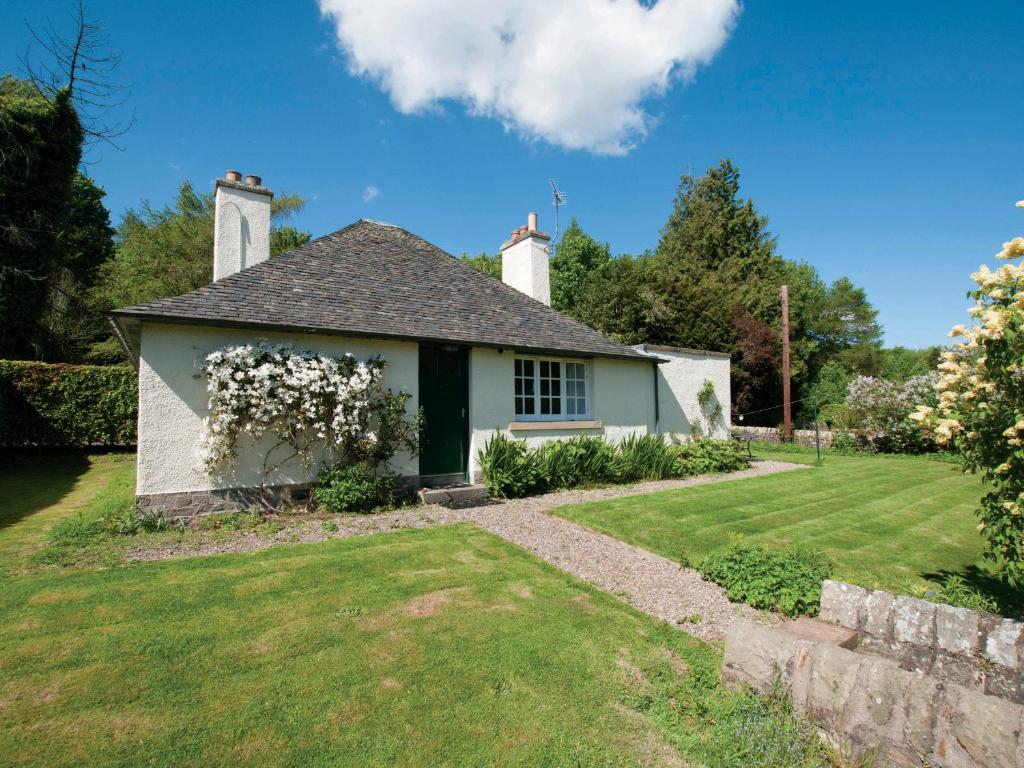 a white house with flowers on the front yard at West Cottage - Tarvit in Cupar