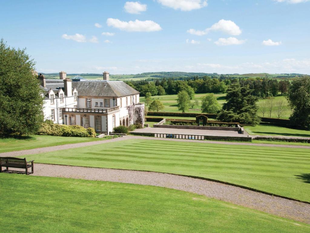 a large estate with a bench in the grass at Upper West Wing Flat - Tarvit in Cupar