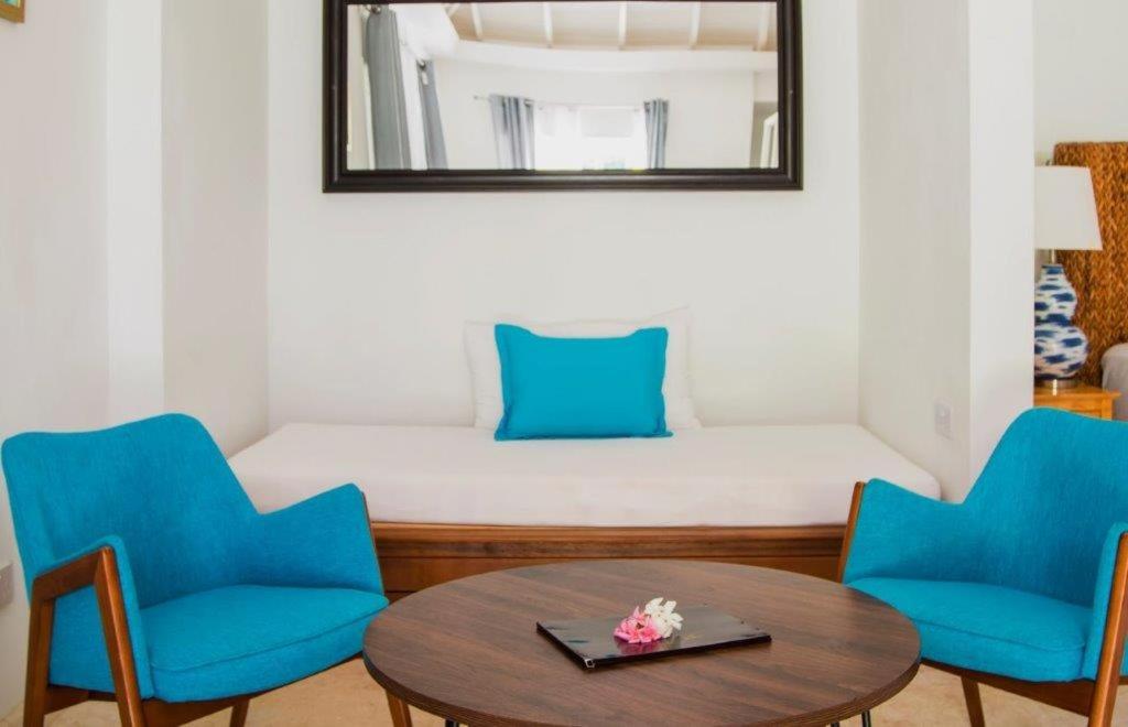 a room with two blue chairs and a table at Bequia Plantation Hotel in Bequia