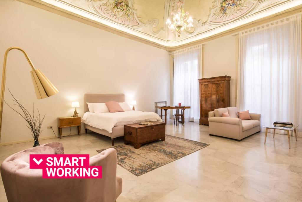 een grote woonkamer met een bed en een bank bij Casa degli Affreschi a Palazzo Lungarini in Palermo