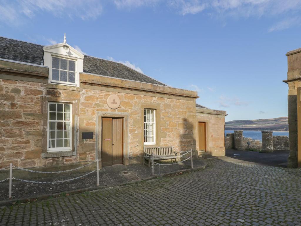 a stone house with a bench in front of it at Royal Artillery Cottage - Culzean Castle in Maybole