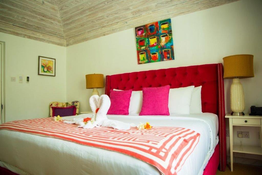 a bedroom with a large bed with two stuffed animals on it at Bequia Plantation Hotel in Bequia