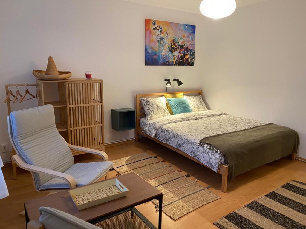 een slaapkamer met een bed, een stoel en een tafel bij La Momo in Lupeni