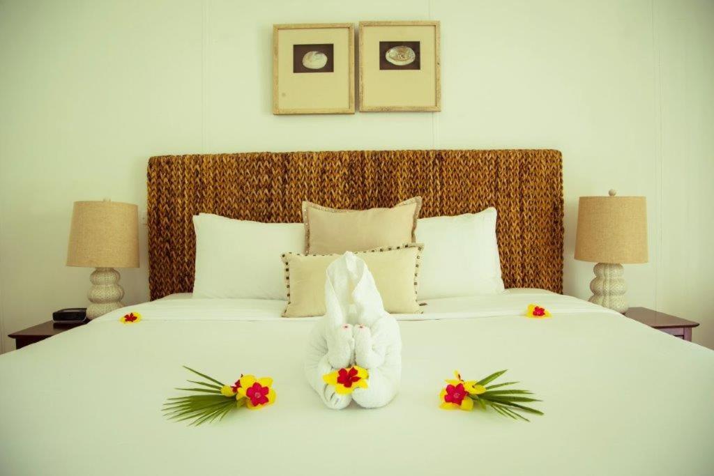 a white bed with two stuffed animals on it at Bequia Plantation Hotel in Bequia