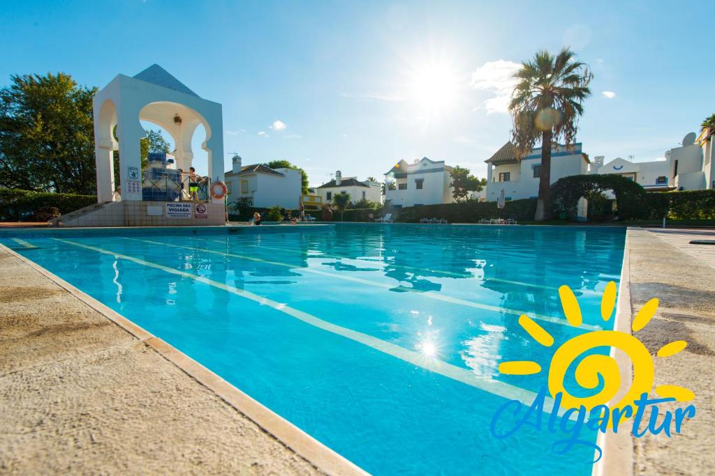 a swimming pool at a resort with blue water at Quinta Velha By Algartur in Cabanas de Tavira