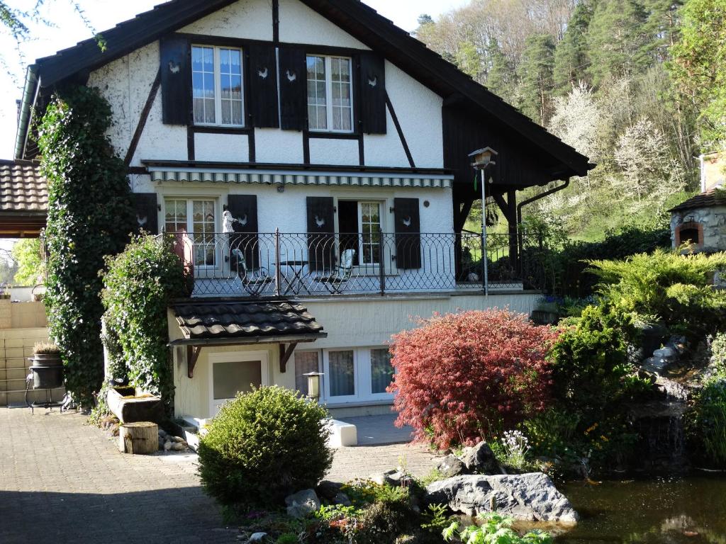 a white and black house with a balcony at Bis Bosserte in Kollbrunn