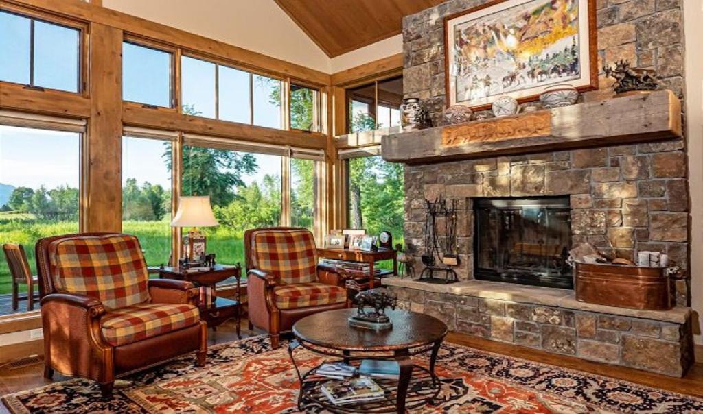 a living room with a stone fireplace and chairs at Teton View Cabin in Jackson