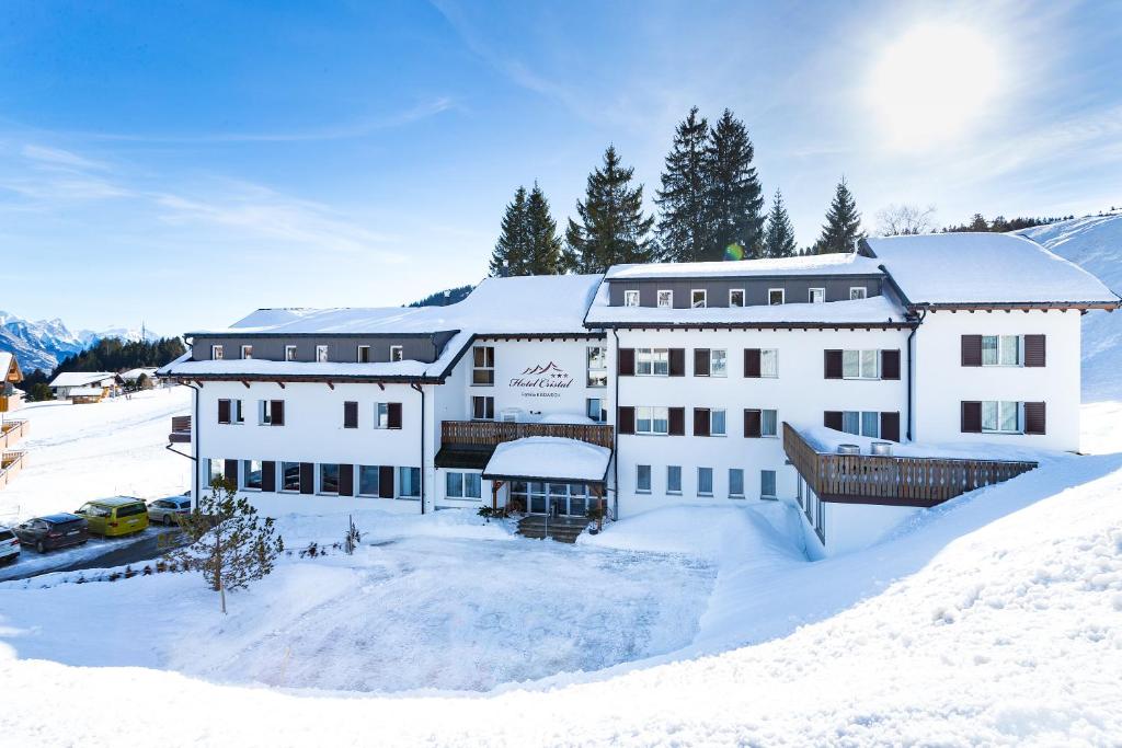 a large white building in the snow at Hotel Cristal Flumserberg in Flumserberg