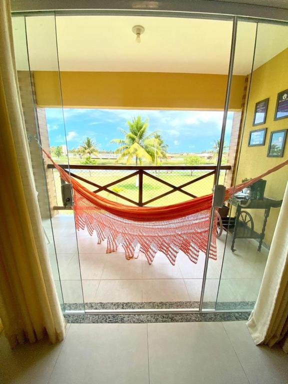 a room with a glass window with a hammock in it at Condomínio Villa das Aguas com wi-fi in Praia do Saco