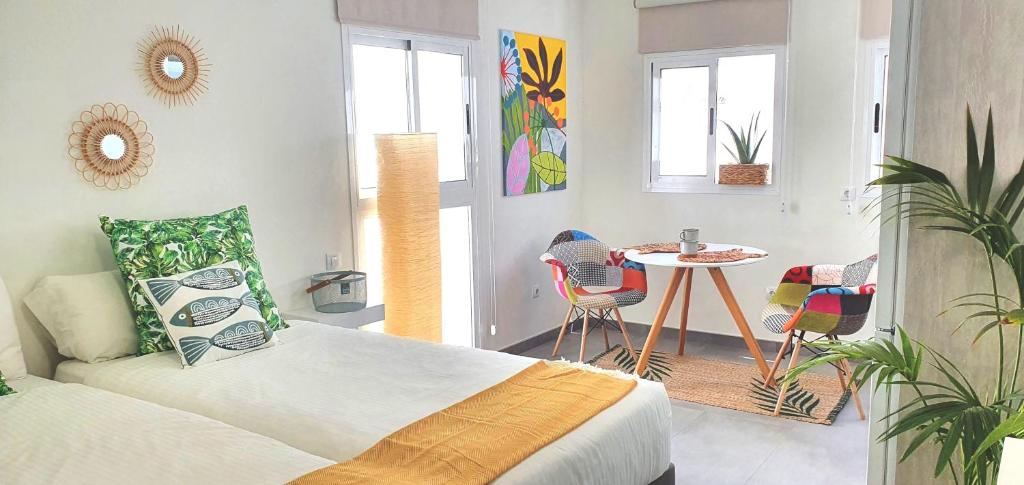 a bedroom with a bed and a table with chairs at HD Mogán Coral Apartments in Puerto de Mogán
