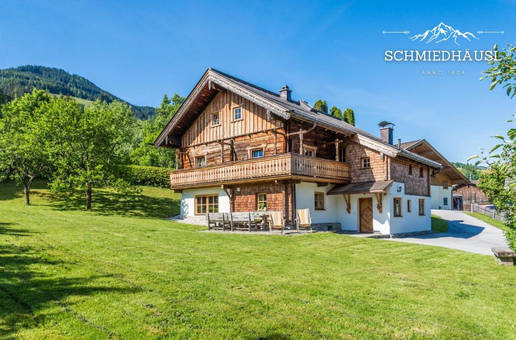 a large wooden house on a grassy field at Schmiedhäusl in Bruck an der Großglocknerstraße