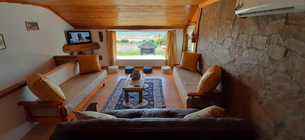 a living room with a couch and a stone wall at LU-MAR in Caviahue