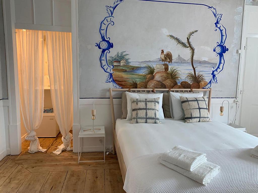 Schlafzimmer mit einem Bett mit Wandgemälde in der Unterkunft Central Studio suite in Ericeira by Lovely Bay in Ericeira