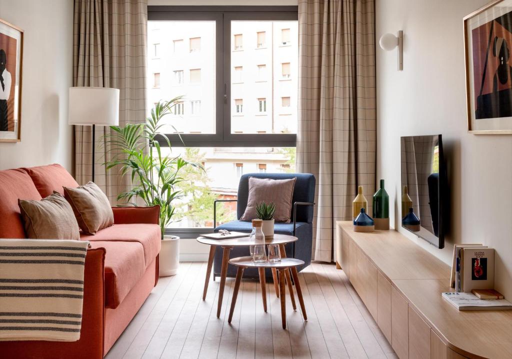a living room with a couch and a table at Apartahotel Líbere Vitoria in Vitoria-Gasteiz