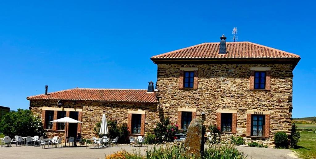 un gran edificio de piedra con techo rojo en Hotel Rural Molino del Arriero, en Luyego de Somoza