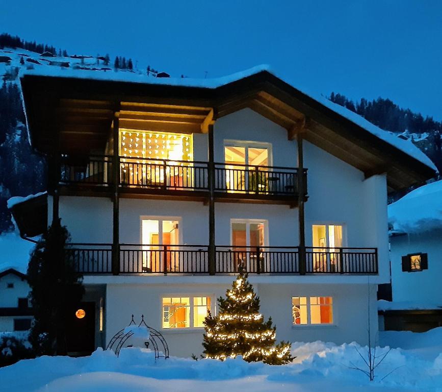 Un árbol de Navidad delante de una casa en Ferienwohnung Judith, en Sillian