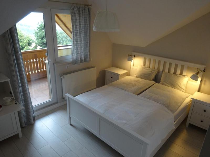 una camera con un grande letto bianco e un balcone di Karkonoski Widok a Dziwiszów