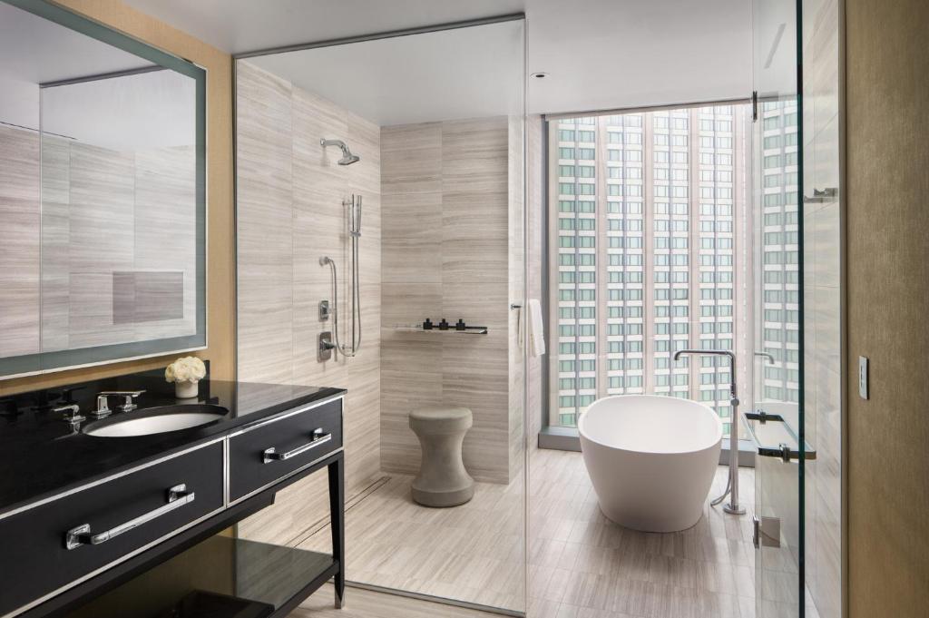 a bathroom with a tub and a shower with a window at Four Seasons Hotel One Dalton Street, Boston in Boston