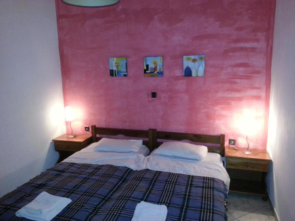 - une chambre dotée d'un lit avec un mur rose dans l'établissement Simple and special, à Ermoúpoli