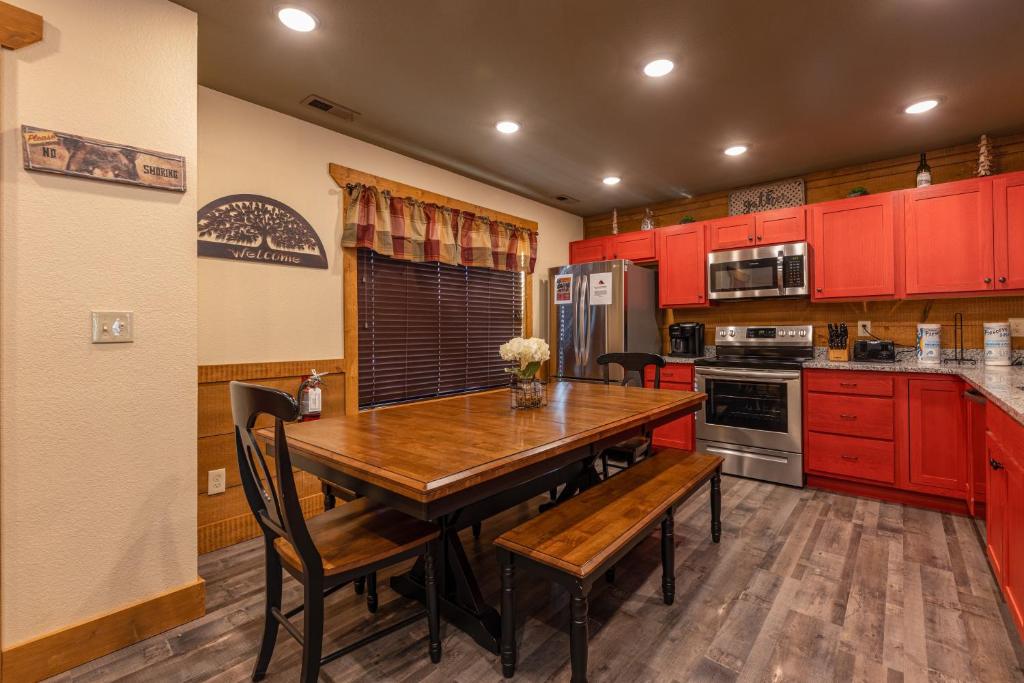 a kitchen with red cabinets and a wooden table and chairs at BearVue Point chalet in Gatlinburg