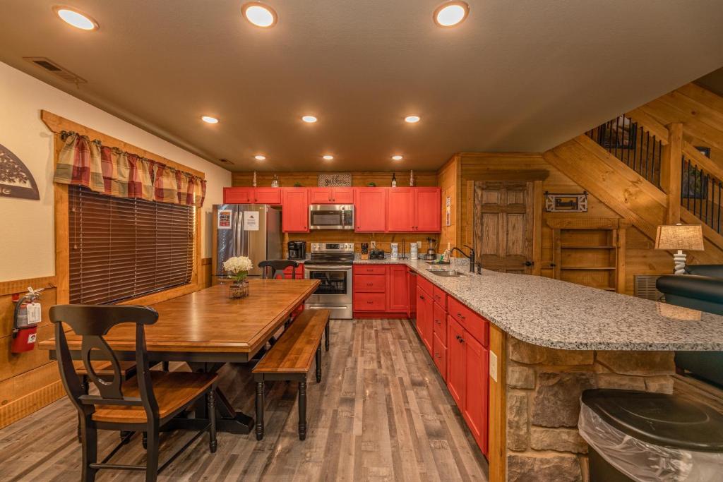 a kitchen with red cabinets and a wooden table at BearVue Point chalet in Gatlinburg