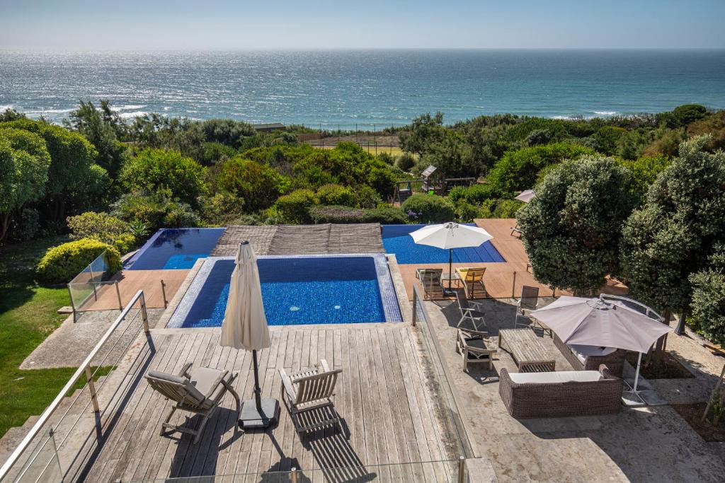 een uitzicht over een zwembad met een oceaan bij Luxury Beachfront Villa in Colares