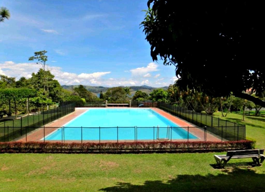 una gran piscina en un parque con un banco en Finca La Esperanza, en Calima