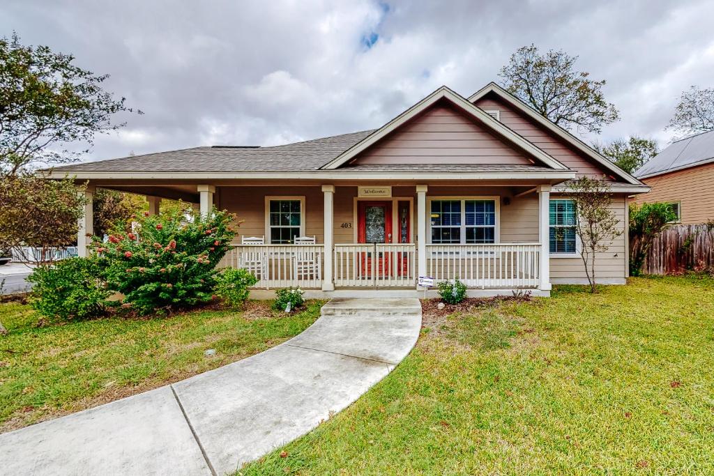 una pequeña casa con porche y entrada en Urban Villita en San Antonio