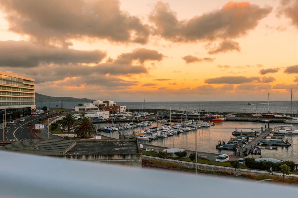 een jachthaven bij zonsondergang met boten in het water bij Casa Vista Marina in Ponta Delgada