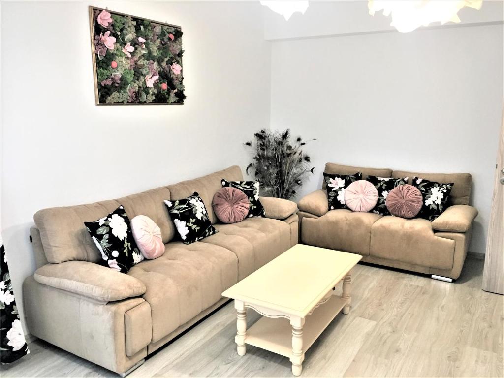 ein Wohnzimmer mit einem Sofa und einem Tisch in der Unterkunft 23 Residence in Braşov