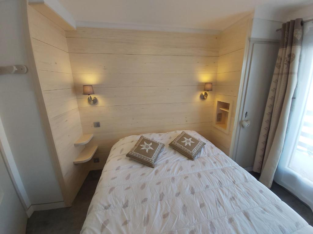 um quarto com uma cama com duas almofadas em Chalet Monte-Pente em Megève