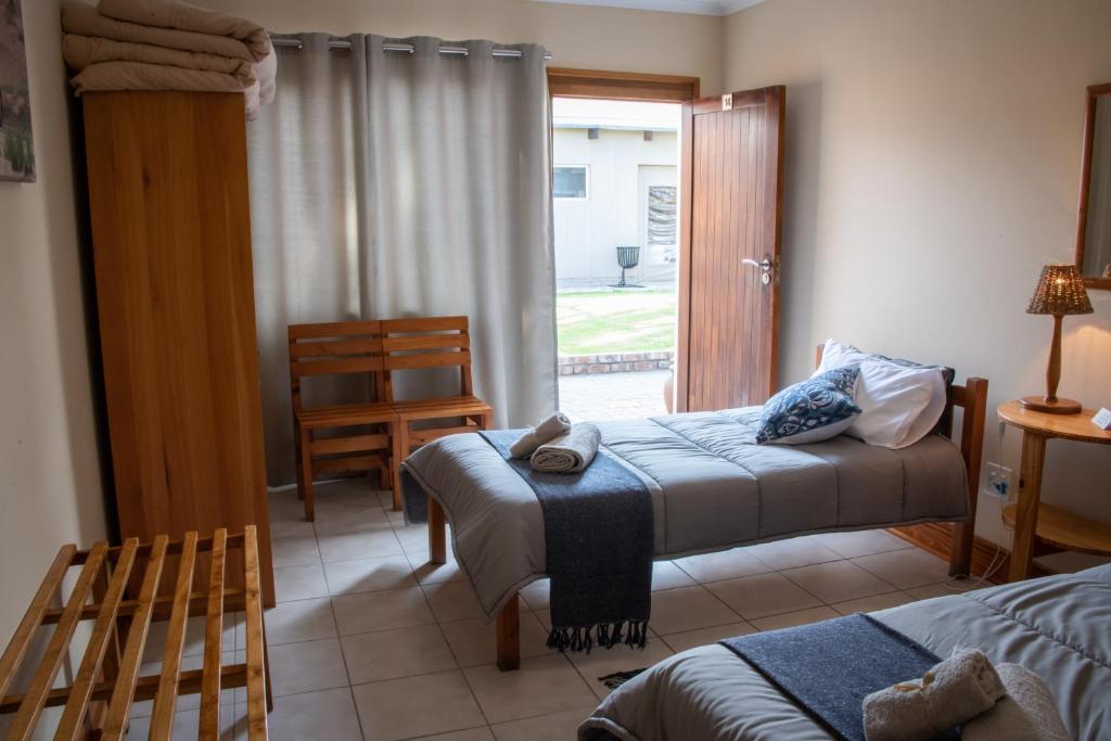 a bedroom with two beds and a sliding glass door at The Mole Guesthouse in Swakopmund