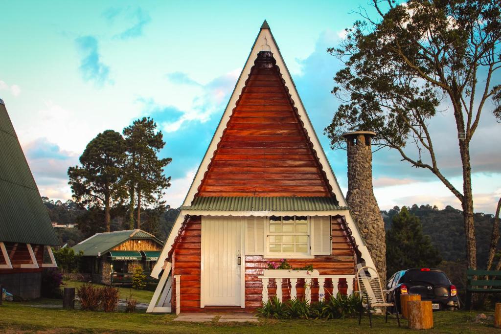 Cette petite maison est dotée d'un toit de chaume. dans l'établissement Pousada Chalés Por do Sol, à Campos do Jordão