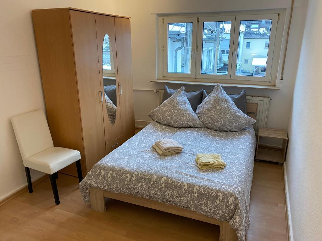 um quarto com uma cama com uma cadeira e uma janela em Gemütliches WG-Zimmer 2, zentral in Ravensburg em Ravensburg