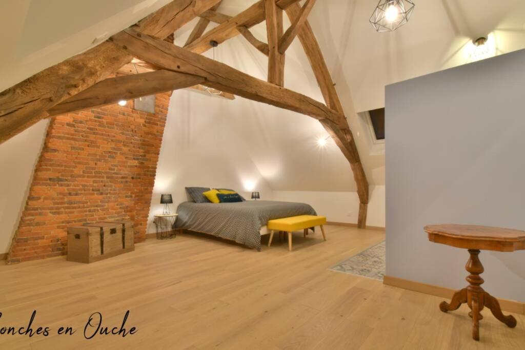 um quarto com uma cama e uma parede de tijolos em Hyper-centre de Conches-en-Ouche. em Conches-en-Ouche