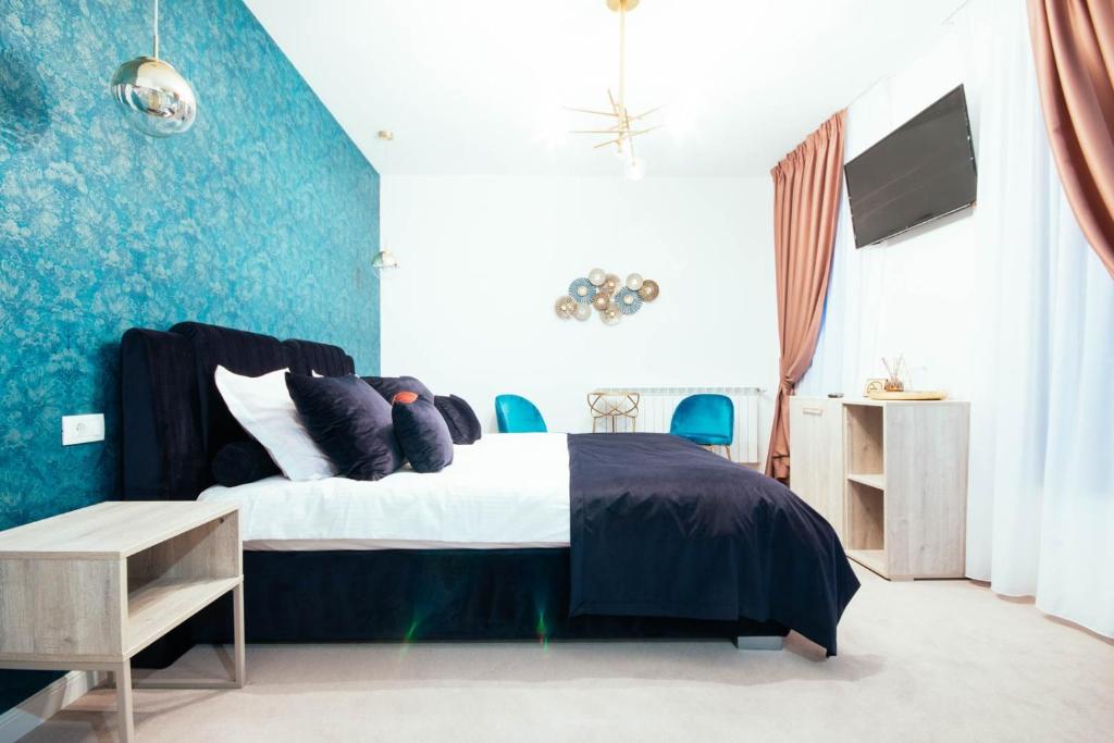 LIANE BOUTIQUE HOTEL في كامبولونغ مولدوفينيسك: غرفة نوم مع سرير بحائط ذات لهجة زرقاء