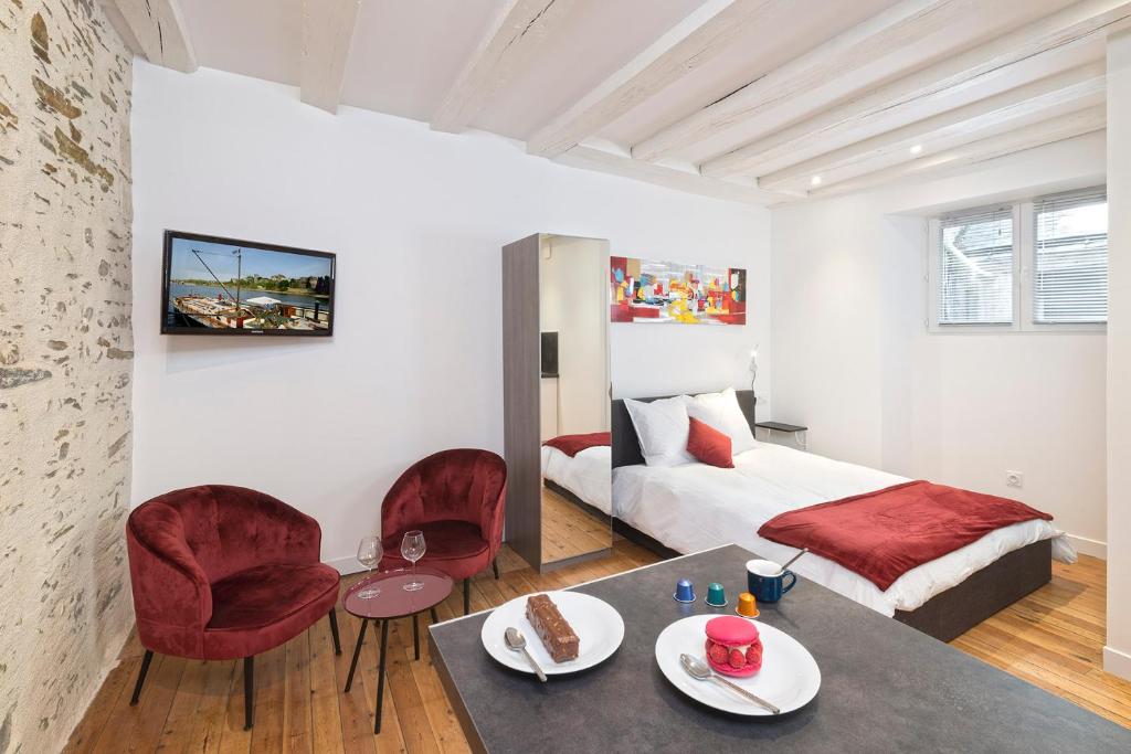 アンジェにあるHypercentre calme et cosy Impasse Saint Julien, 1er étageのベッドとテーブルと椅子のある寝室