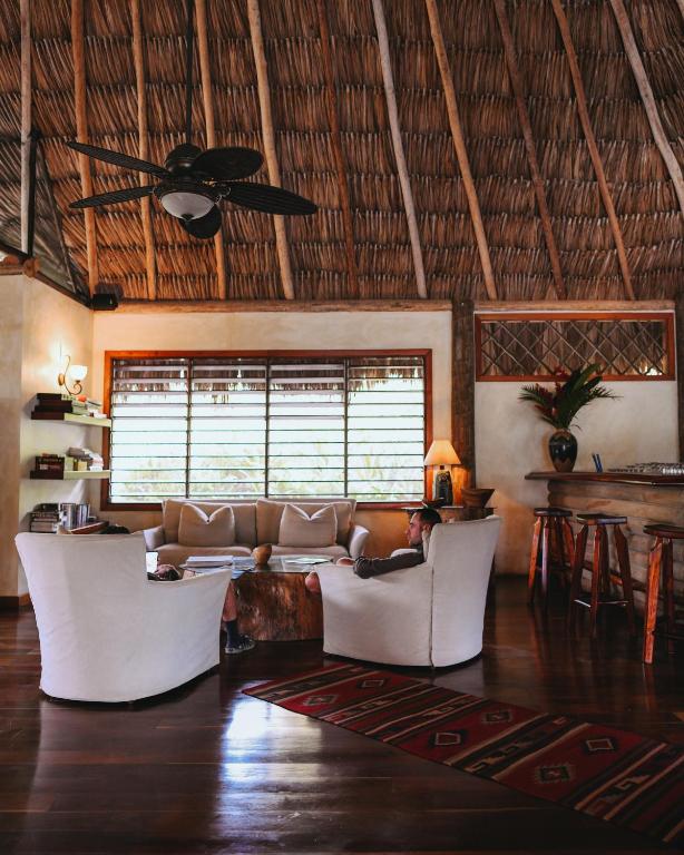 a man sitting on a couch in a living room at Gaia Riverlodge in San Ignacio