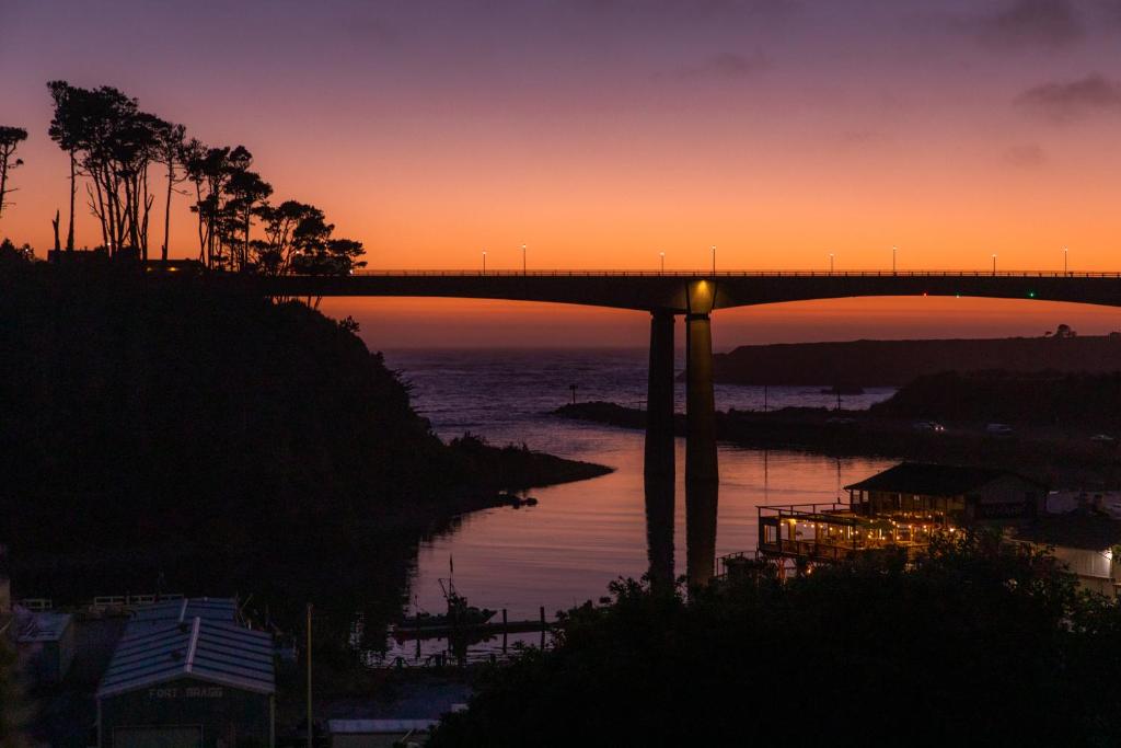 a bridge over a body of water at sunset at Noyo Harbor Inn in Fort Bragg
