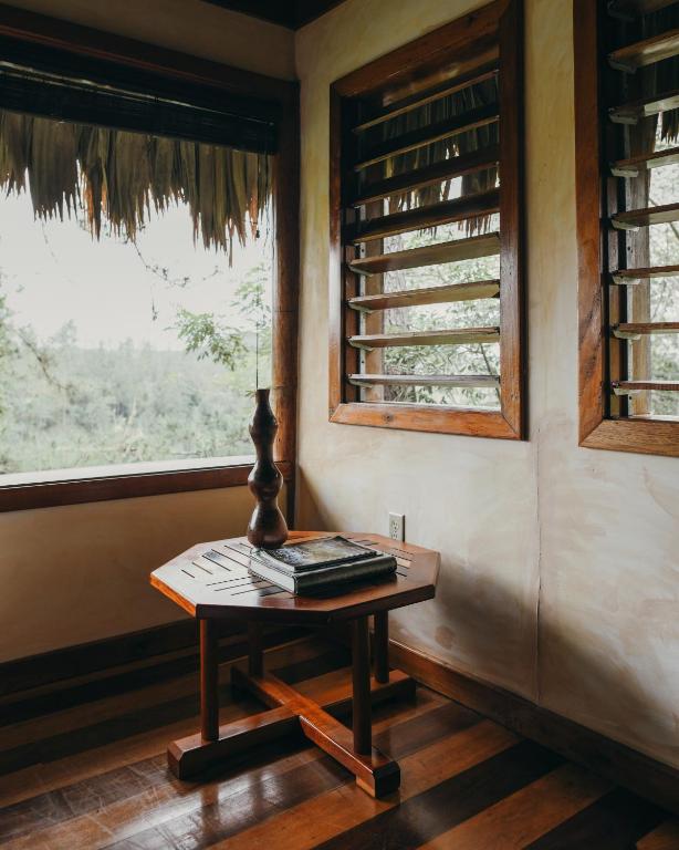 a table in the corner of a room with a window at Gaia Riverlodge in San Ignacio