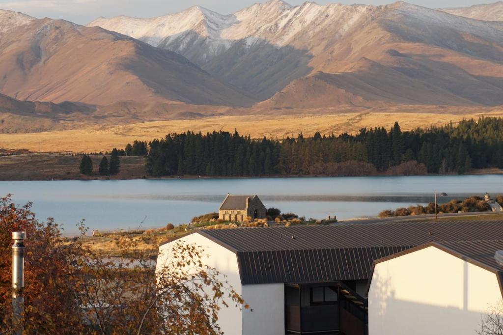 a house with a view of a lake and mountains at The Godley Hotel in Lake Tekapo