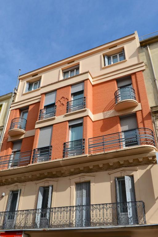 a tall building with balconies on top of it at Hôtel Colisée-Verdun Centre Gare Saint-Roch in Montpellier