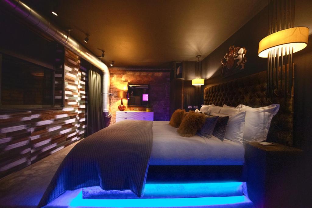 a bedroom with a large bed with blue lighting at The Bells - Luxury Serviced Apartments in Leeds
