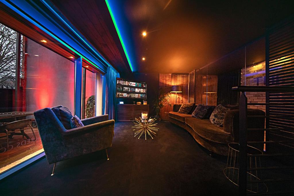 a living room with a couch and chairs and lights at The Bells - Luxury Serviced Apartments in Leeds