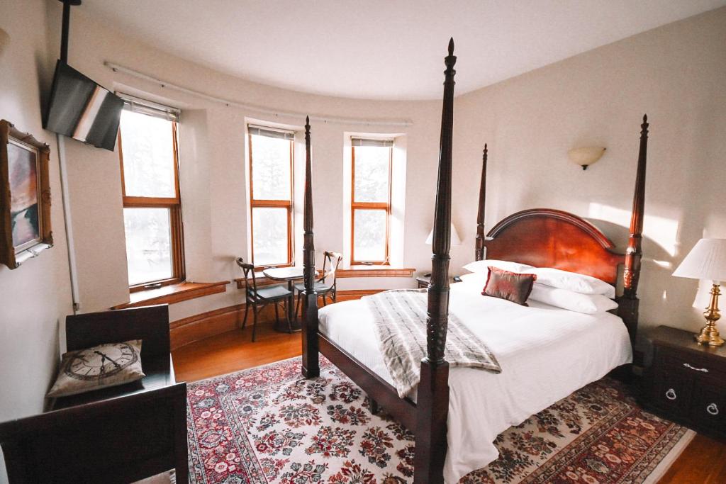 - une chambre avec un lit à baldaquin et des fenêtres dans l'établissement Bellas Castle, à Morden